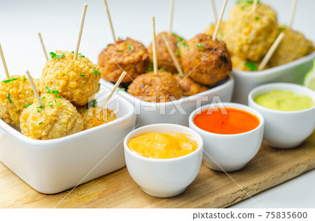 Various mini chicken kievs and sweet potato falafels served with sauces Various mini chicken kievs and sweet potato falafels served with sauces 75835600