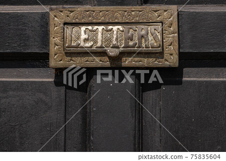 Old letterbox in the door, traditional way of delivering letters to the house, old mailbox 75835604