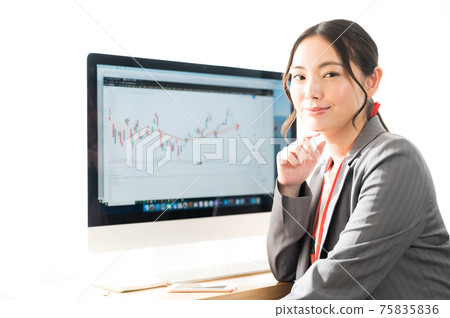 在TradingView提供的股票圖表屏幕前微笑的女性交易員 在TradingView提供的股票圖表屏幕前微笑的女性交易員 75835836