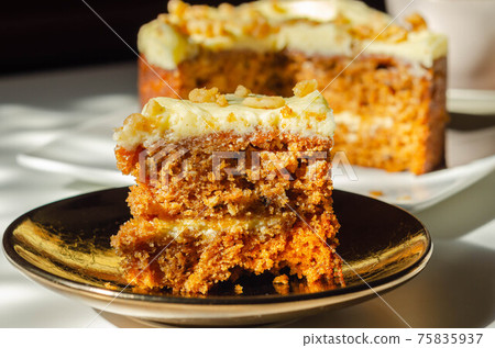 Sliced carrot cake filled and topped with cream cheese buttercream and decorated with walnuts Sliced carrot cake filled and topped with cream cheese buttercream and decorated with walnuts 75835937
