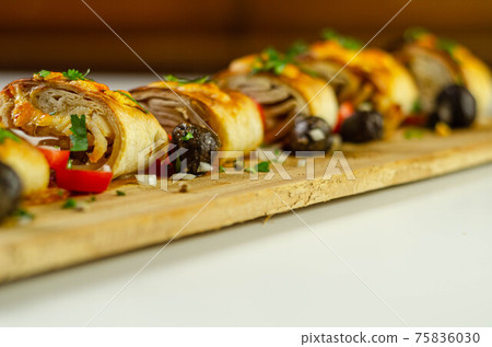 Baked pieces of tortilla wrap with chicken breast and Grana Padano cheese on the wood Baked pieces of tortilla wrap with chicken breast and Grana Padano cheese on the wood 75836030