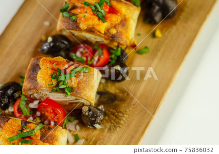 Baked pieces of tortilla wrap with chicken breast and Grana Padano cheese on the wood Baked pieces of tortilla wrap with chicken breast and Grana Padano cheese on the wood 75836032