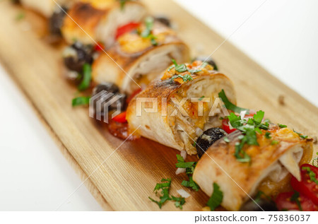 Baked pieces of tortilla wrap with chicken breast and Grana Padano cheese on the wood Baked pieces of tortilla wrap with chicken breast and Grana Padano cheese on the wood 75836037