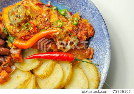 Chicken breast fillet with a chilli and cheese tomato sauce with crispy potato slices and minty bean salad on a blue plate Chicken breast fillet with a chilli and cheese tomato sauce with crispy potato slices and minty bean salad on a blue plate 75836105