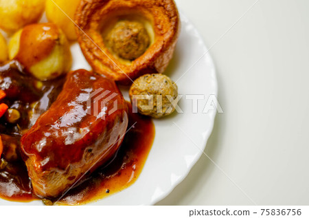 Roast potatoes and roast chicken breast in a chicken and white wine gravy with peas, carrots, pork and onion stuffing and a Yorkshire pudding Roast potatoes and roast chicken breast in a chicken and white wine gravy with peas, carrots, pork and onion stuffing and a Yorkshire pudding 75836756