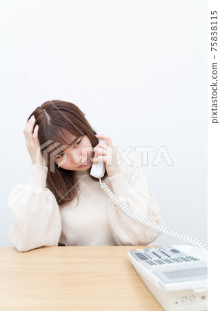 一個女人在座機上講話時擔心 一個女人在座機上講話時擔心 75838115