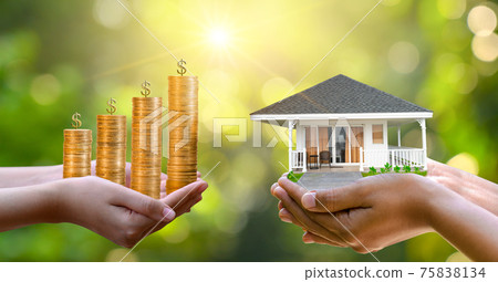 The hands of a businessman hold money and the other hand holds a house. The idea of saving money to buy a house The hands of a businessman hold money and the other hand holds a house. The idea of saving money to buy a house 75838134
