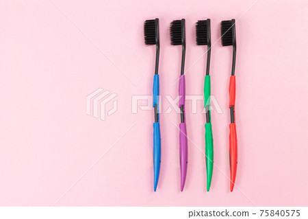 Set of colorful plastic toothbrushes with black bristles. Space for text Set of colorful plastic toothbrushes with black bristles. Space for text 75840575