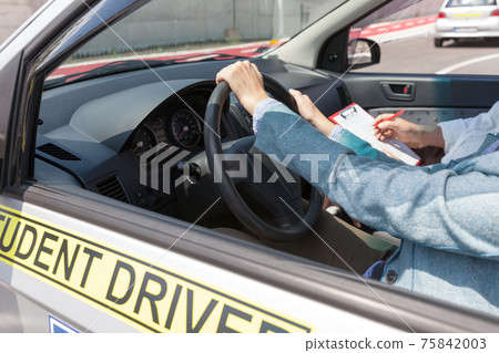 Learning to drive a car with a driving instructor. Student driver. 75842003