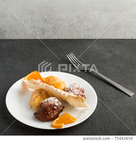 Carnival dessert on plate isolated on black background Carnival dessert on plate isolated on black background 75842650