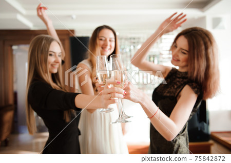 Group people with champagne dancing at the party. 75842872