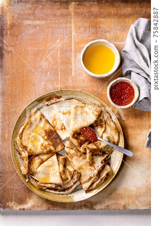 Thin pansakes with red caviar and butter 75842887