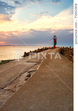Beacon at the end of a pier in Swinoujscie at sunset, Poland. Beacon at the end of a pier in Swinoujscie at sunset, Poland. 75842909