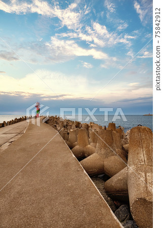 Beacon at the end of a pier in Swinoujscie at sunset, Poland. Beacon at the end of a pier in Swinoujscie at sunset, Poland. 75842912