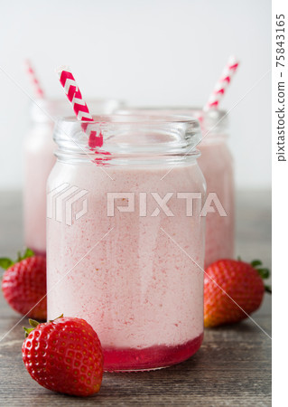 Delicious strawberry smoothie on wooden table Delicious strawberry smoothie on wooden table 75843165