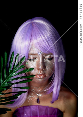 A girl with purple hair and glowing skin. An alien or a fairy with glowing skin. Eyes closed, a palm tree branch in front of his face. Pacification 75844145