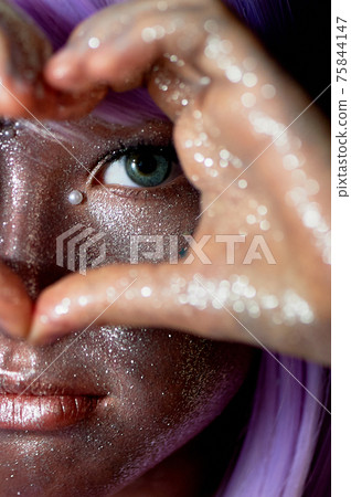 A girl with purple hair and glowing skin. An alien or a fairy with glowing skin. Her hands are folded in front of her face in a heart shape A girl with purple hair and glowing skin. An alien or a fairy with glowing skin. Her hands are folded in front of her face in a heart shape 75844147