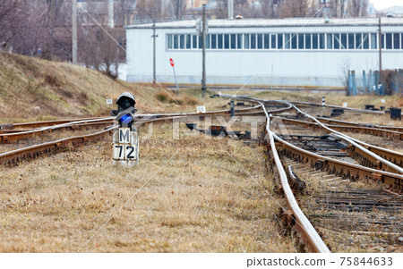 Blue control traffic light at the fork of the old railway on a spring day. 75844633