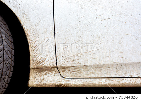 white dirty car in the splash of the slurry the driver door and the front fender of the vehicle closeup, nobody. 75844820