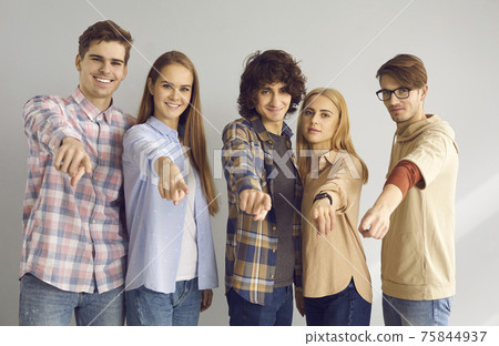 Group of happy young people standing together and pointing at camera choosing you Group of happy young people standing together and pointing at camera choosing you 75844937
