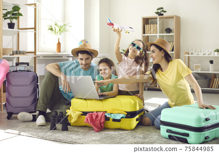 Happy family and kids with travel suitcase buying ticket booking hotel online 75844985