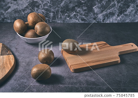 Three kiwis on a wooden board 75845785