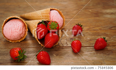 Strawberry ice cream in a waffle cone. Red berries and ice cream balls 75845806
