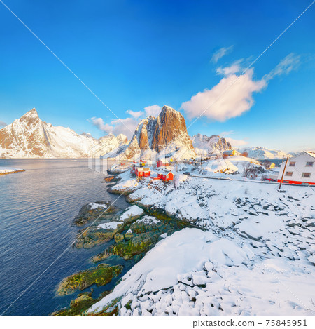 Picturesque winter view on Hamnoy village and Festhaeltinden mountain on background. Picturesque winter view on Hamnoy village and Festhaeltinden mountain on background. 75845951