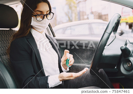 Businesswoman in a black mask sitting inside a car 75847461