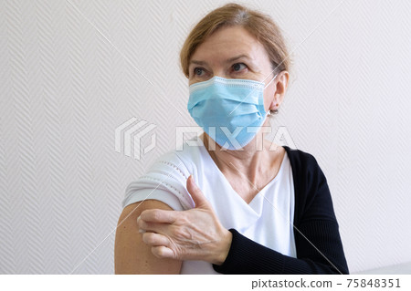 Woman being vaccinated in her hands on a white background in a hospital. Routine vaccination against Woman being vaccinated in her hands on a white background in a hospital. Routine vaccination against 75848351