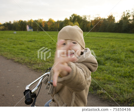 little cute real boy on bicycle emotional smiling close up outside in green amusement park little cute real boy on bicycle emotional smiling close up outside in green amusement park 75850436