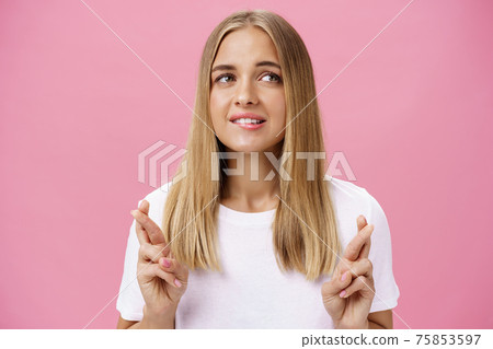 Woman having dream wanting desire come true crossing fingers for good luck, making wish biting lower lip while daydreaming about thing she wants buy looking aside posing over pink background Woman having dream wanting desire come true crossing fingers for good luck, making wish biting lower lip while daydreaming about thing she wants buy looking aside posing over pink background 75853597