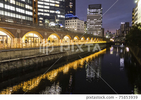 古老的Manseibashi站高架橋的照明和神田河的夜景 75853939