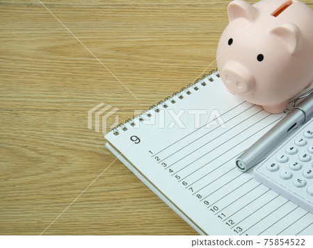 A piggy bank on wood table for Finance or saving money business content. A piggy bank on wood table for Finance or saving money business content. 75854522