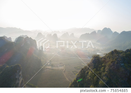 Aerial view of beatiful sunrise over karst mountain peak landscape Aerial view of beatiful sunrise over karst mountain peak landscape 75854885