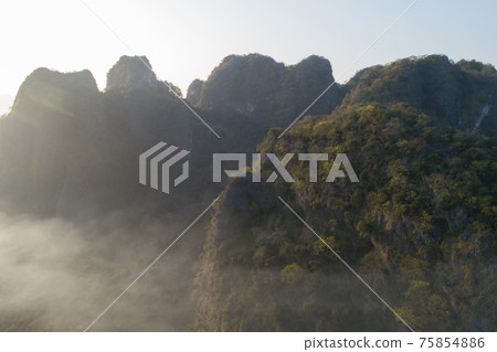 Aerial view of beatiful sunrise over karst mountain peak landscape Aerial view of beatiful sunrise over karst mountain peak landscape 75854886