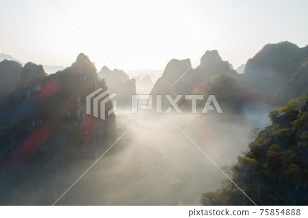 Aerial view of beatiful sunrise over karst mountain peak landscape 75854888