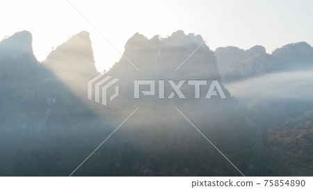 Aerial view of beatiful sunrise over karst mountain peak landscape Aerial view of beatiful sunrise over karst mountain peak landscape 75854890