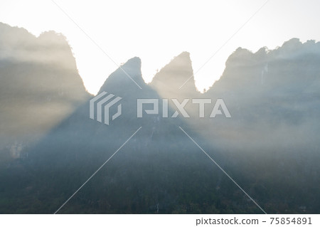 Aerial view of beatiful sunrise over karst mountain peak landscape Aerial view of beatiful sunrise over karst mountain peak landscape 75854891