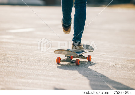 Skateboarder skateboarding outdoors on sunny morning 75854893
