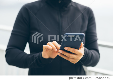 Asian woman using smartphone outdoors 75855330