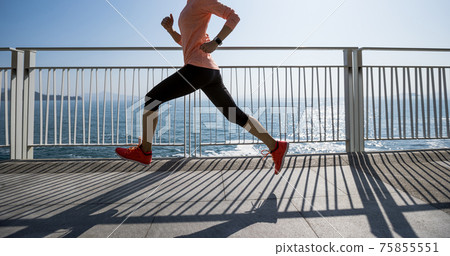 Healthy lifestyle fitness sports woman runner running on seaside trail 75855551