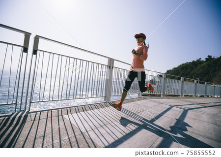 Healthy lifestyle fitness sports woman runner running on seaside trail 75855552