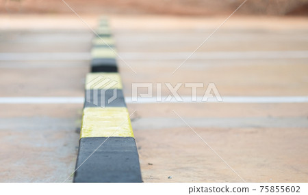 Row of concrete wheel stopper, selective soft focus. Row of concrete wheel stopper, selective soft focus. 75855602
