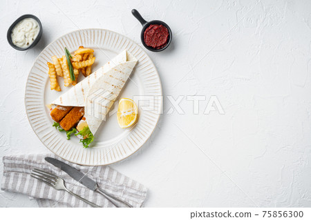Tortilla roll with fish fingers, cheese and vegetables, on plate, on white background, top view flat lay , with copyspace and space for text Tortilla roll with fish fingers, cheese and vegetables, on plate, on white background, top view flat lay , with copyspace and space for text 75856300