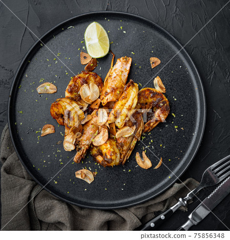 Large grilled BBQ shrimp with sweet Mango sauce and curry, on plate, on black background, top view flat lay 75856348
