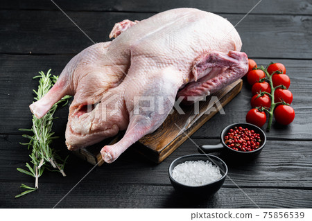 Raw whole mallard duck on black wooden table 75856539