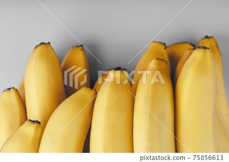 Fresh bunch of yellow bananas isolated on a Gray background Trendy colors of 2021 Fresh bunch of yellow bananas isolated on a Gray background Trendy colors of 2021 75856613