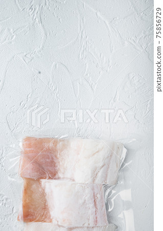 Haddock white fish fillet in plastic market pack, on white background, top view with copy space for text 75856729