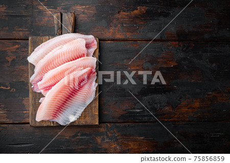 Raw tilapia fish fillet meat, on old wooden table, top view with copy space for text 75856859
